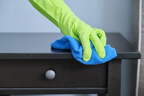 Cleaner wiping down furniture with a microfiber cloth